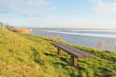 Modern recreation area, forest park, lake. Wooden benches, tables. Camping site. Soft sunlight, clear sky. Early spring. Idyllic landscape. Nature, environment, ecology, ecotourism, vacations, weekendの写真素材