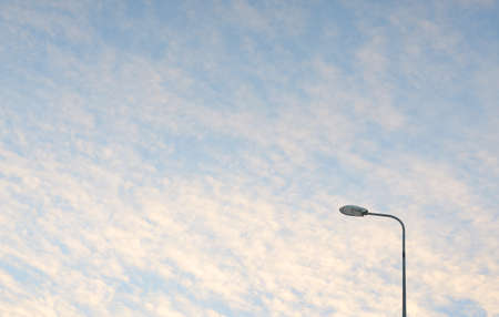 Street lights (lantern) against dramatic sunset sky. Glowing pink and golden clouds after the storm....