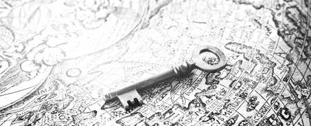 Retro styled key and old white nautical chart close-up. Vintage still life. Travel, navigation, collecting, souvenir, gift, home, accessories, graphic resource. Black and white imageの写真素材