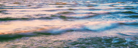 Sea waves and splashes texture. Colorful sky reflecting in the water. Idyllic seascape. Concept image, long exposure. Picturesque scenery. Background, wallpaper, natural pattern, graphic resourcesの写真素材