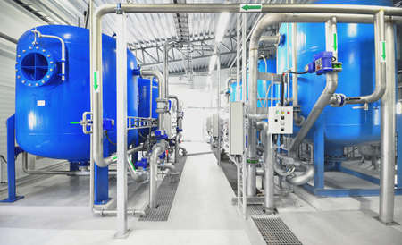 Large blue tanks in a industrial city water treatment boiler room. Wide angle perspective....