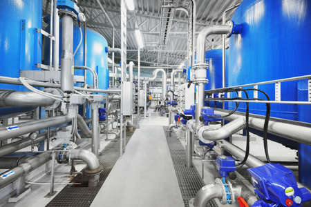 Large blue tanks in a industrial city water treatment boiler room. Wide angle perspective....