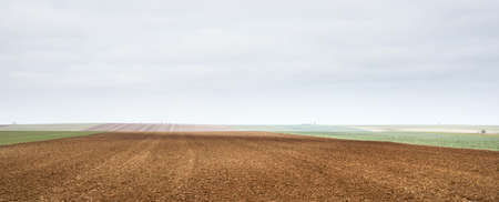 Panoramic scenery of the plowed agricultural field. Dramatic sky. France, Europe. Autumn, seasons,...