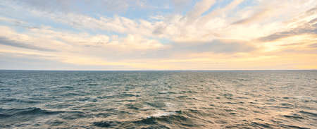 Panoramic view of the Baltic sea after the storm at sunrise. Dramatic sky with glowing clouds. Epic cloudscape. Fickle weather, ecology, climate change, seasonsの写真素材