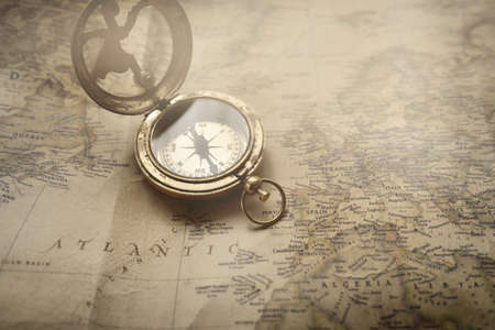 Retro style antique golden compass (sundial) and old nautical chart close-up. Vintage still life....
