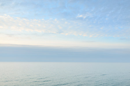 Panoramic aerial view from the Baltic sea shore at sunset. Dramatic cloudscape, glowing clouds, golden sunlight after the storm. Nature, environment, climate change, fickle weatherの写真素材
