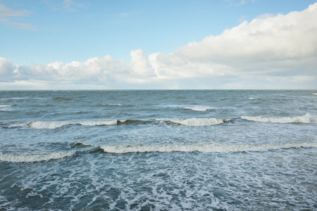 Baltic sea under dramatic sunset clouds after the storm. Waves, splashing water. Epic seascape. 40-50 knots wind force. Cyclone, gale, storm, rough weather, meteorology, ecology, climate changeの写真素材