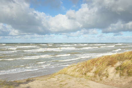 Baltic sea shore (sand dunes, beach) after the storm. Dramatic sky, glowing clouds. Picturesque...