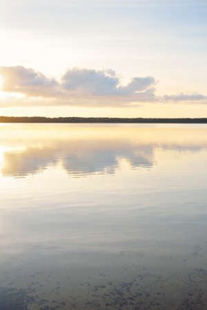 Forest lake (river) at sunset. Glowing clouds, symmetry reflections in a crystal clear water....
