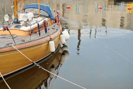 Modern classic wooden swedish cruising sailboat moored to a pier in a yacht marina. Tourism,...