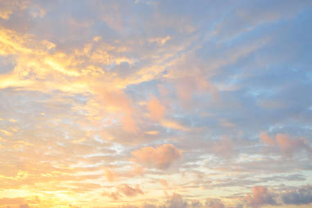 Clear blue sky. glowing pink and golden cirrus and cumulus clouds after storm, soft sunlight....