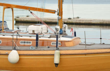 Modern classic wooden swedish cruising sailboat moored to a pier in a yacht marina. Tourism,...