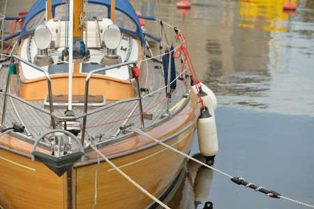 Modern classic wooden swedish cruising sailboat moored to a pier in a yacht marina. Tourism,...