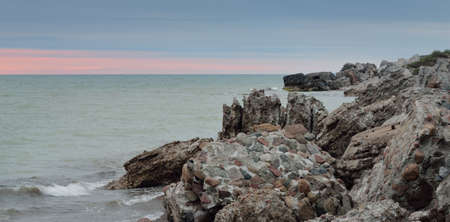 Panoramic view from the Baltic sea shore (beach) at sunset. Ruins and rocks. Picturesque scenery....