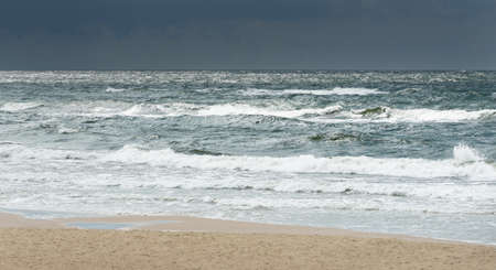 Baltic sea shore (sand dunes, beach) after the storm. Dramatic sky, glowing clouds. Picturesque panoramic scenery. Nature, environment, ecology, ecotourism, hiking, exploring conceptsの写真素材