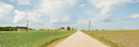 Driving a car through the green country fields and forest on a sunny day. Clear blue sky. Idyllic...