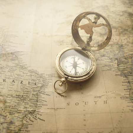 Retro style antique golden compass (sundial) and old nautical chart close-up. Vintage still life. Sailing accessories. Wanderlust, travel and navigation theme. Graphic resources, copy spaceの写真素材