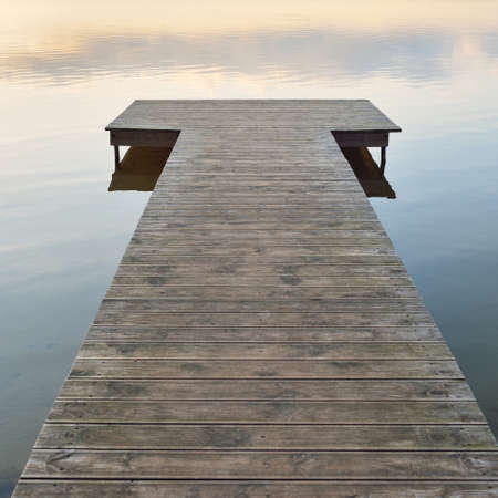 Forest lake (river) at sunset. Wooden pier. Glowing clouds, symmetry reflections in a still crystal clear water. Idyllic landscape. Nature, ecology, ecological reserve, ecotourism, hiking, vacationsの写真素材