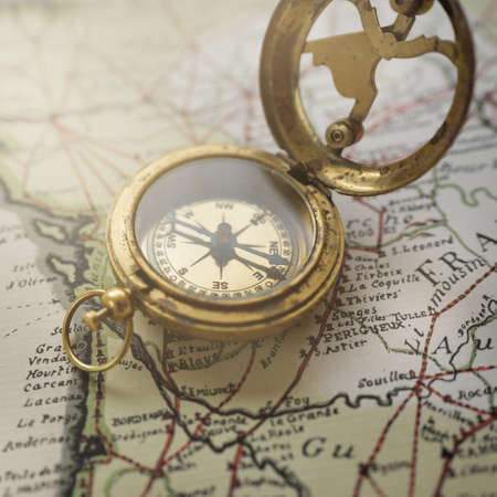 Retro style antique golden compass (sundial) and old nautical chart close-up. Vintage still life. Sailing accessories. Wanderlust, travel and navigation theme. Graphic resources, copy spaceの写真素材