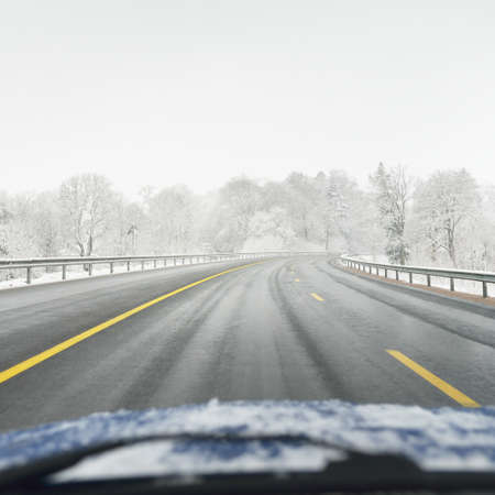 Empty highway (asphalt road) through the snow-covered forest. Canada. Nature, christmas vacations, remote places, winter tires, dangerous driving conceptの写真素材
