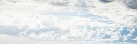 Ornamental clouds. Dramatic sky. Epic storm cloudscape. Soft sunlight. Panoramic image, texture, background, graphic resources, design, copy space. Meteorology, heaven, hope, peace conceptの写真素材