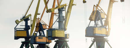 Modern coal terminal in Riga, Latvia. Cranes close-up. Baltic sea. Freight transportation, logistics, global communications, economy, business, industry, supply, special equipment. Urban landscapeの写真素材