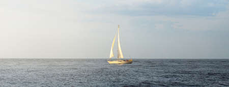 Sloop rigged yacht sailing in the Baltic sea. Sunset. Dramatic sky after the storm, soft sunlight....