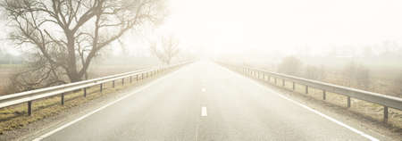 Panoramic view of the empty highway (new asphalt road) through the fields on a sunny spring day....