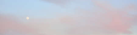 Clear blue sky, glowing pink and golden clouds after storm at sunset. Dramatic cloudscape. Moon,...