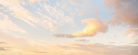 Clear blue sky. glowing pink and golden cirrus and cumulus clouds after storm, soft sunlight....