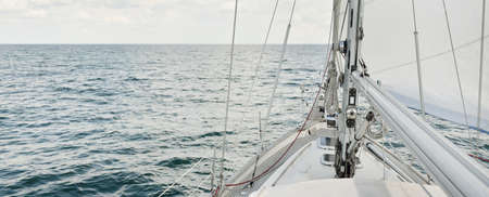 Herreshoff designed old classic yacht sailing in an open sea. Wooden teak deck. View to the mast and...