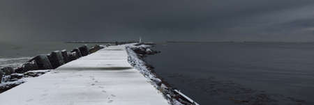 Baltic sea after the storm. Breakwaters, old pier (promenade) to the lighthouse. Picturesque panoramic scenery, seascape. Nature, environment, rough weather, climate changeの写真素材