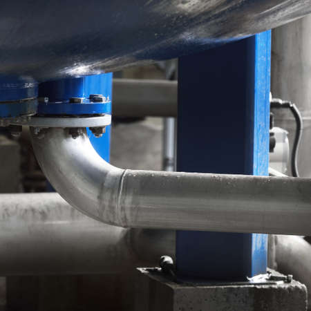 Industrial water treatment and boiler room. Shiny steel metal pipes, piping, connections, pumps....