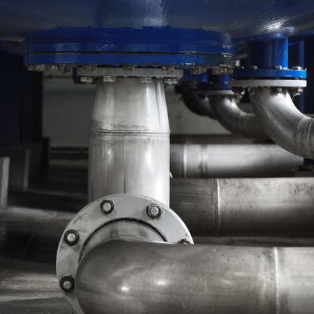 Industrial water treatment and boiler room. Shiny steel metal pipes, piping, connections, pumps....