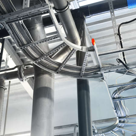 Industrial water treatment and boiler room. Shiny steel metal pipes, piping, connections, pumps....