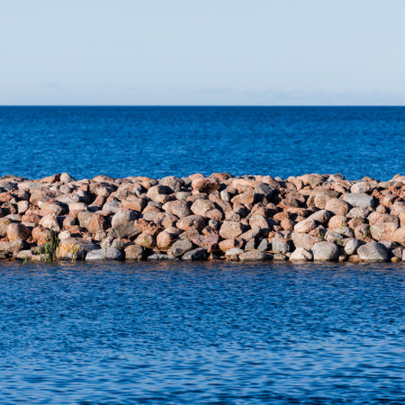 A view of the Baltic sea shore at sunset. Clear sky. Waves and water splashes. Idyllic seascape. Ruhnu island, Estoniaの写真素材