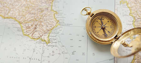 Retro style antique golden compass (sundial) and old nautical chart close-up. Vintage still life....