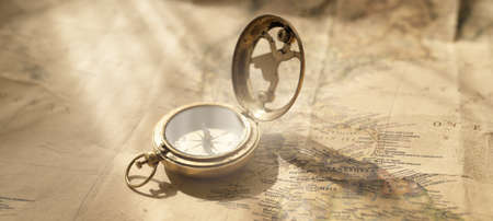 Retro style antique golden compass (sundial) and old nautical chart close-up. Vintage still life....