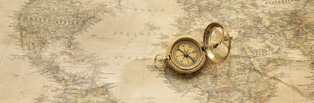 Retro style antique golden compass (sundial) and old nautical chart close-up. Vintage still life....