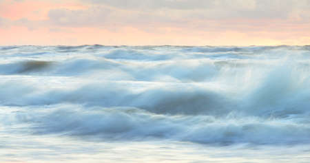 Sea waves and splashes texture. Colorful sky reflecting in the water. Idyllic seascape. Concept...