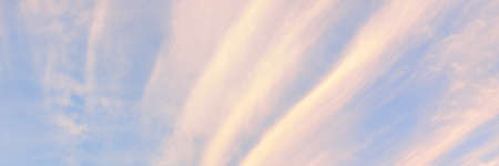 Clear blue sky with glowing pink cirrus and cumulus clouds after storm at sunset. Dramatic...