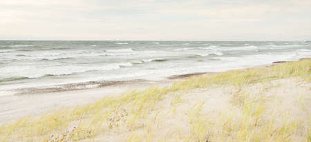 Baltic sea coast (sand dunes) after the storm at sunset. Clear sky, glowing clouds, wind. Autumn...