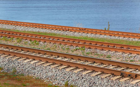 Railroad. Blue water in the background.. Concept urban landscape. Freight transportation, global communications, environment, ecological damage themesの写真素材