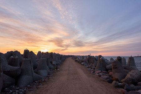 Baltic sea after the storm. Breakwaters. Dramatic sky, glowing clouds, soft sunlight, midnight sun. Picturesque dreamlike seascape, cloudscape. Nature, environment. Panoramic viewの写真素材
