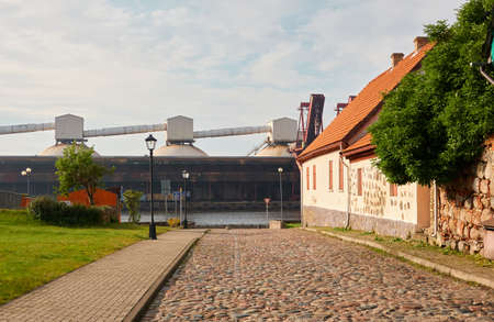 An empty street in Ventspils old town, Latvia..Cargo port terminal in the background. Summer...