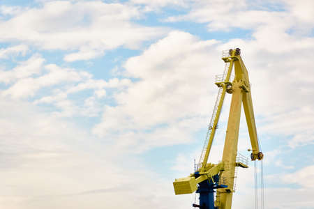 Cargo port terminal in Ventspils, Latvia. Cranes close-up. Baltic sea. Dramatic sunset sky. Freight...