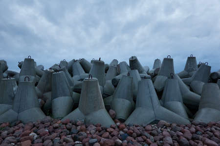 Baltic sea at night. Dramatic sky, storm clouds. Breakwaters close-up. Dark atmospheric seascape....