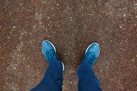 Man standing on the ground. Blue jeans and boots. Soil texture. Concept landscape. Spring, early...