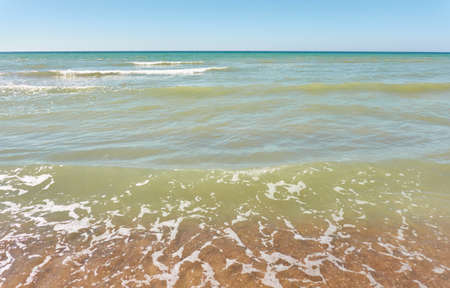 Baltic sea shore on a sunny day. View from a sandy beach sand dunes). Clear blue sky, turquoise...