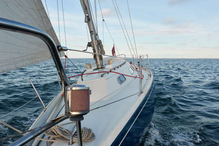 Yacht deck, mast, sail. Top down (high angle) view. Sea, waves and water splashes. clear blue sky....